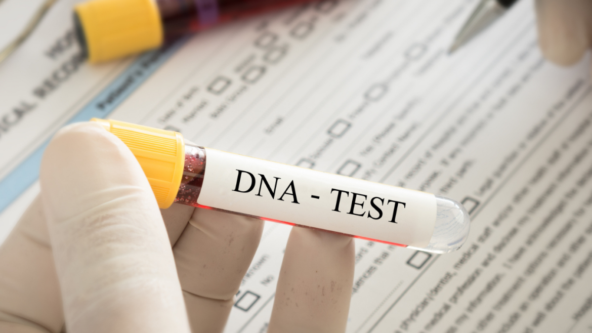 Close up shot of hand wearing white glove holding vile labeled "DNA Test" while filling out paperwork.